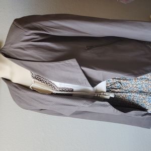 Lightweight jacket features sculpted shoulders, draped lapels, day to night look